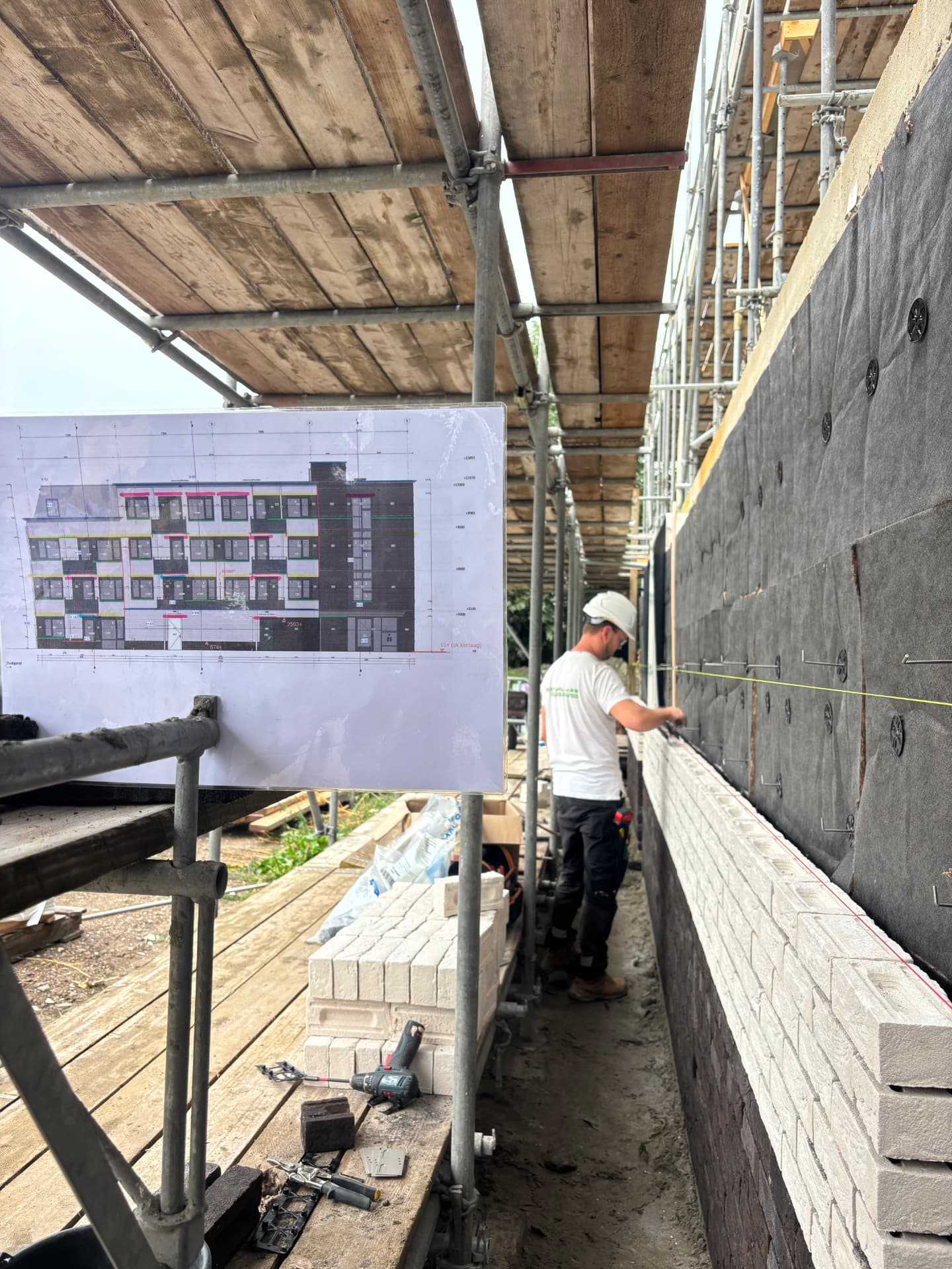 24 appartementen Hengelo, doorkijk langs de steiger met bouwtekening en opgetrokken gevel