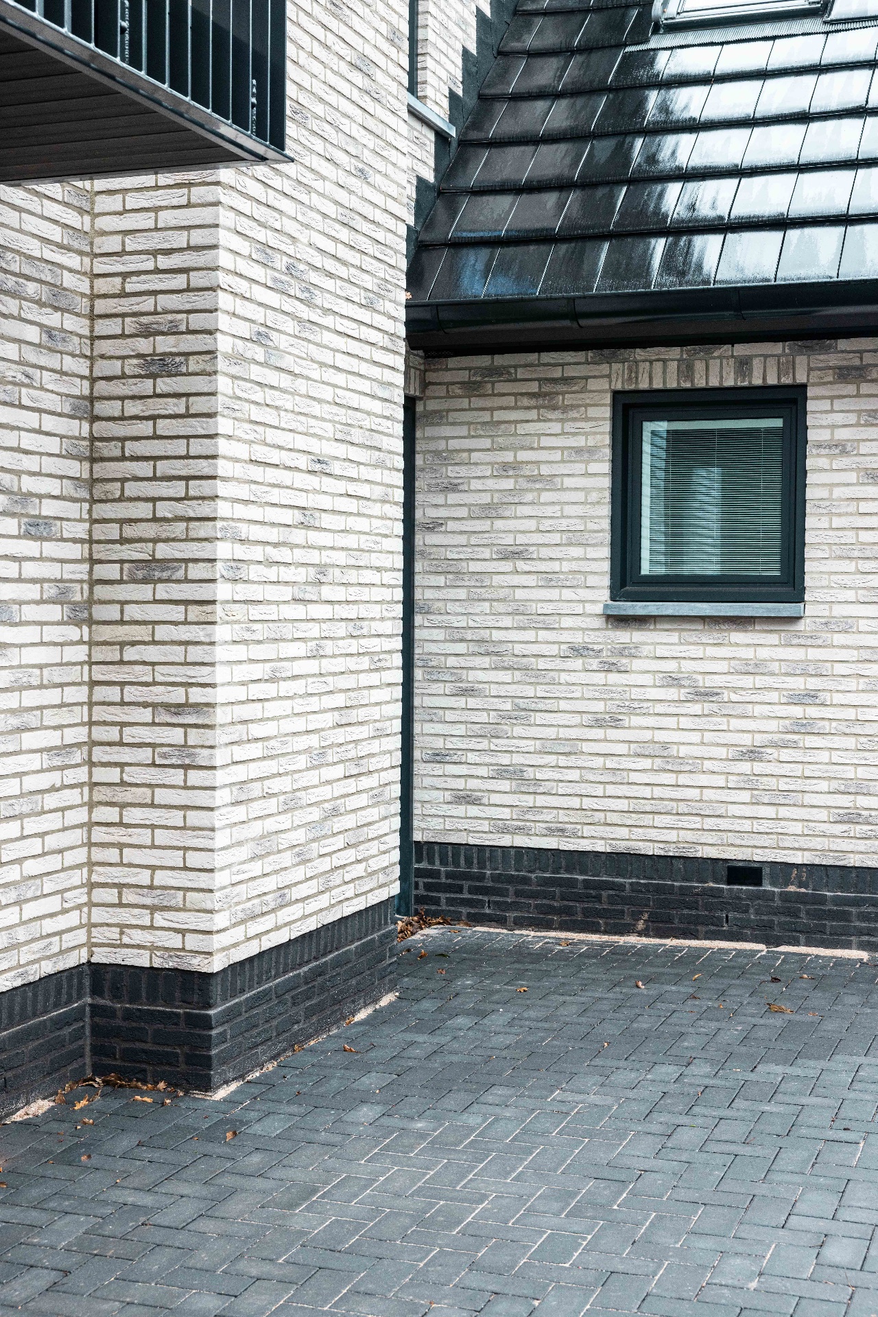 Eeuwigelaan Bergen, witte bakstenen gevel met donkere plint en hoekdetail